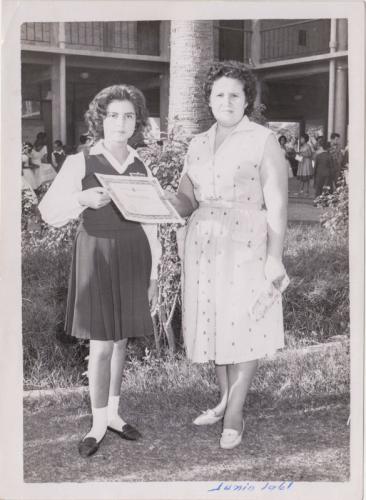 La estudíante Diana Morales de la Esc. Carlos A. Carrillo recibe un diploma de su maestra Ma. del Rosario López Ramos. Junio 22 de 1961.
