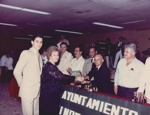 Profra. Ma. del Rosario López Ramos recibiendo la presea Martin M. Herrera de manos del Presidente Mun. Heberto Villarreal. 1987.