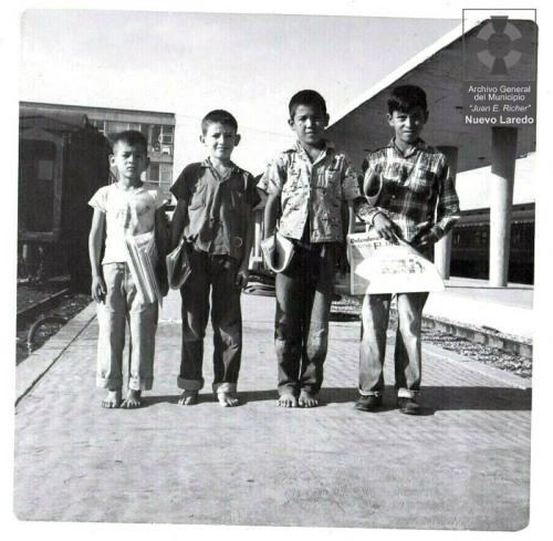 Pequeños voceadores en el anden de la estación de ferrocarril de Nuevo Laredo. Década de 1950.