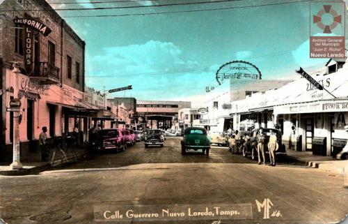 Postal coloreada con la imagen de la Avenida Guerrero a la altura de la esquina con Belden. Mediados de siglo XX.