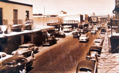 Vista de la Avenida Guerrero de Nuevo Laredo rumbo al norte. Al fondo la Garita Miguel Alemán. Mediados del siglo XX.